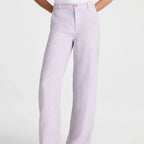 A person wearing light lavender wide-leg linen pants with a white top and black flip-flop sandals, shown from the waist down against a light gray studio background.